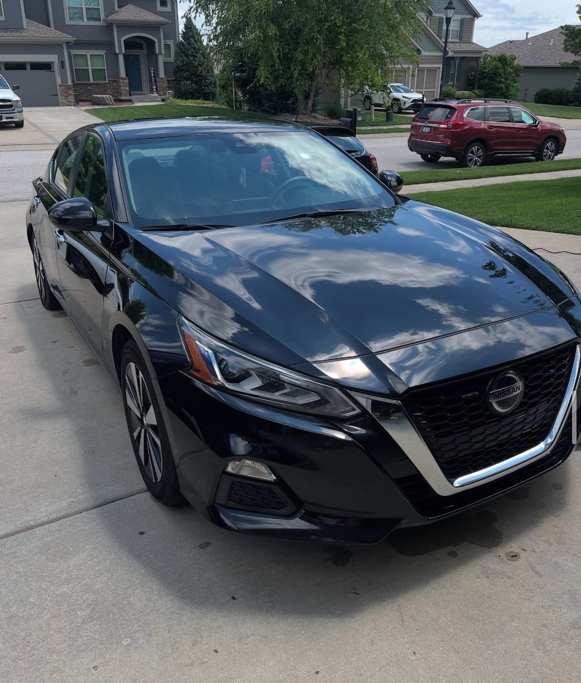 Freshly detailed dark blue Jaguar in a driveway
